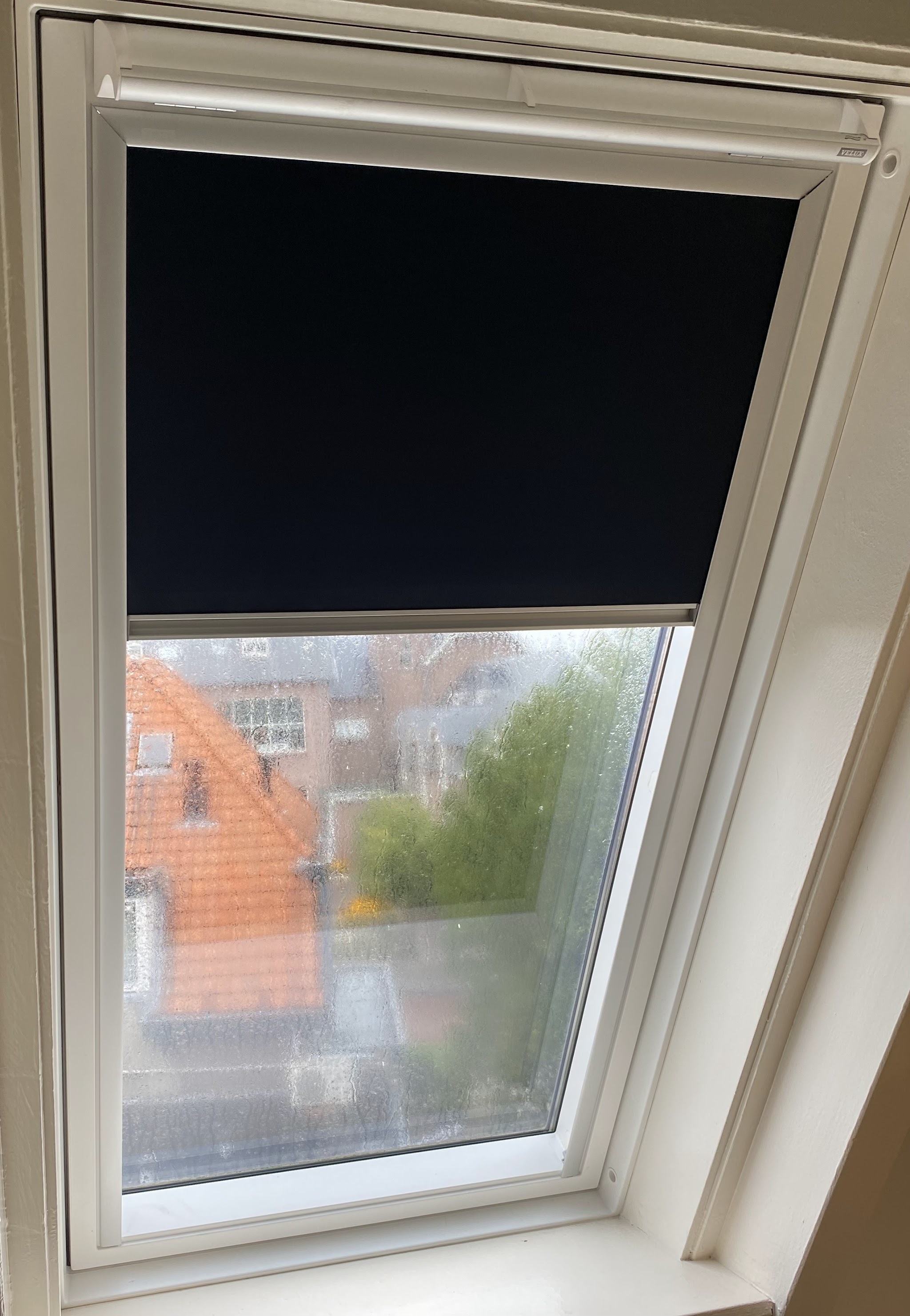 Verduisterend rolgordijn in een dakraam, strak binnen het kozijn gemonteerd