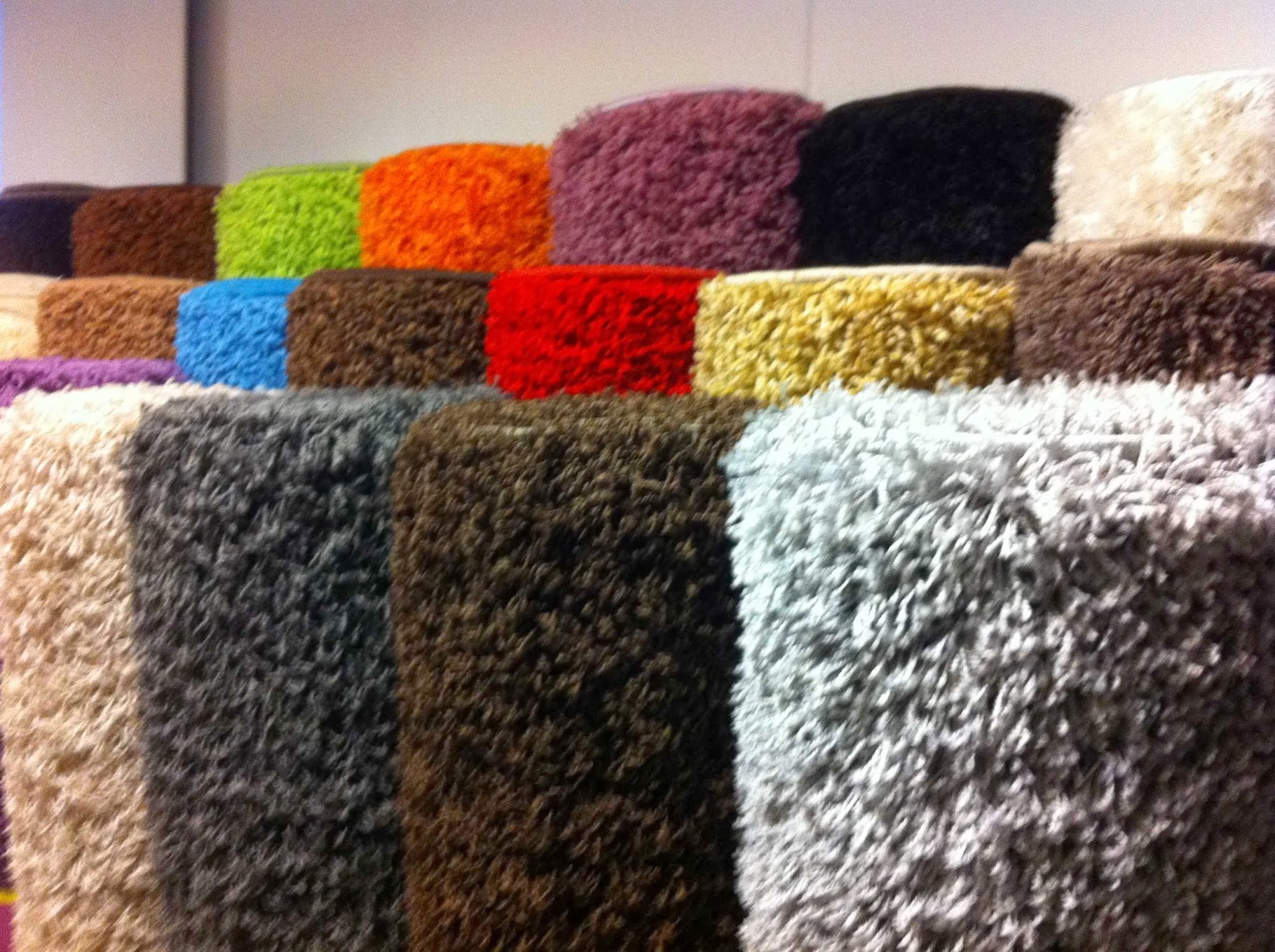 Opgerolde vloerkleden in tientallen kleuren in de showroom