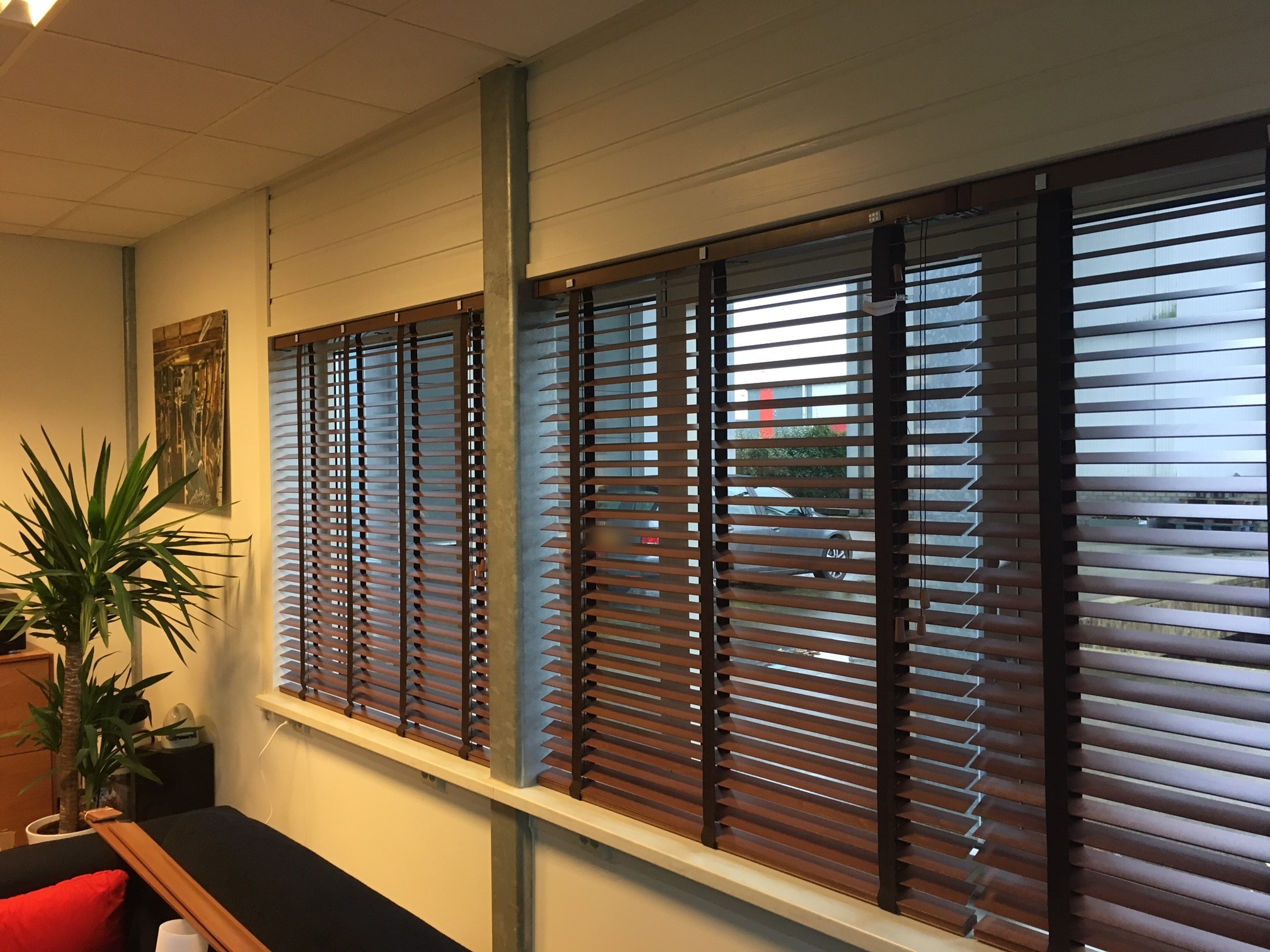 Walnootkleurige houten jaloezieën met ladderband in de showroom